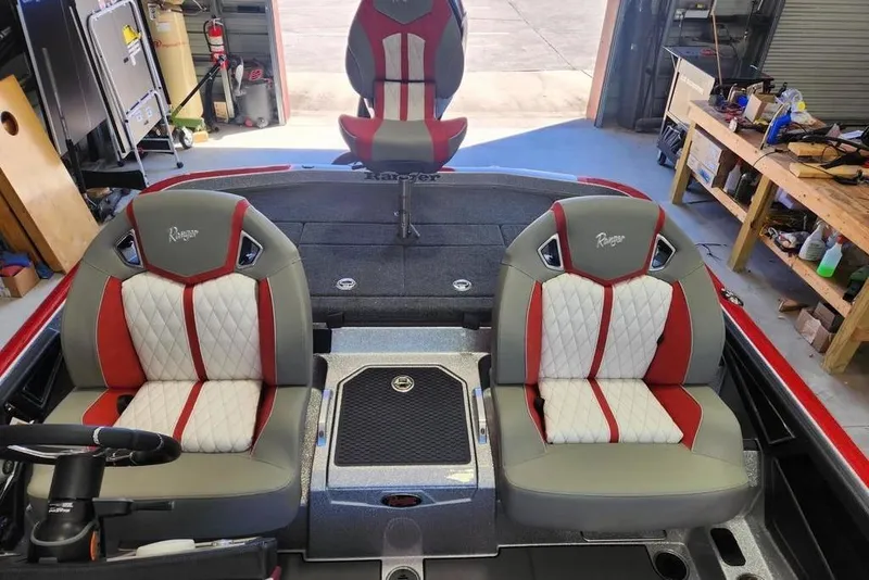 Slide: The Image of 2026 Ranger Z520R Cup-Equipped boat interior with red and white seats in a garage setting. - 8