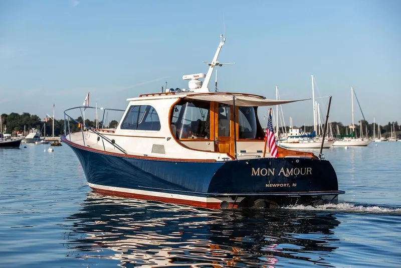 Slide: The Image of 2005 Hinckley Talaria 44 yacht cruising on calm waters with marina background. - 2