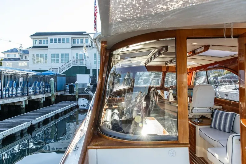 Slide: The Image of Luxurious interior of 2005 Hinckley Talaria 44 yacht with wooden table and cushioned seating. - 20