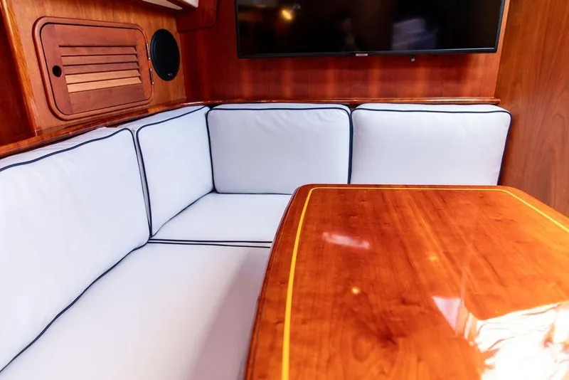 Slide: The Image of Hinckley Talaria 44 yacht kitchen interior, featuring wood cabinetry, countertop, stove, and microwave. - 22