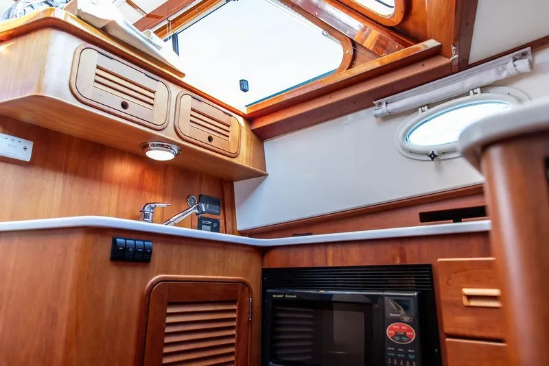 Slide: The Image of Luxurious 2005 Hinckley Talaria 44 yacht interior with modern kitchen and wooden flooring. - 25
