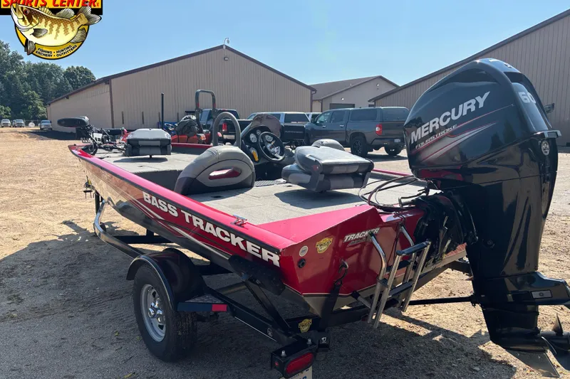 Slide: The Image of 2013 Tracker Pro Team 175 TXW bass boat with Mercury engine, parked outdoors. - 3