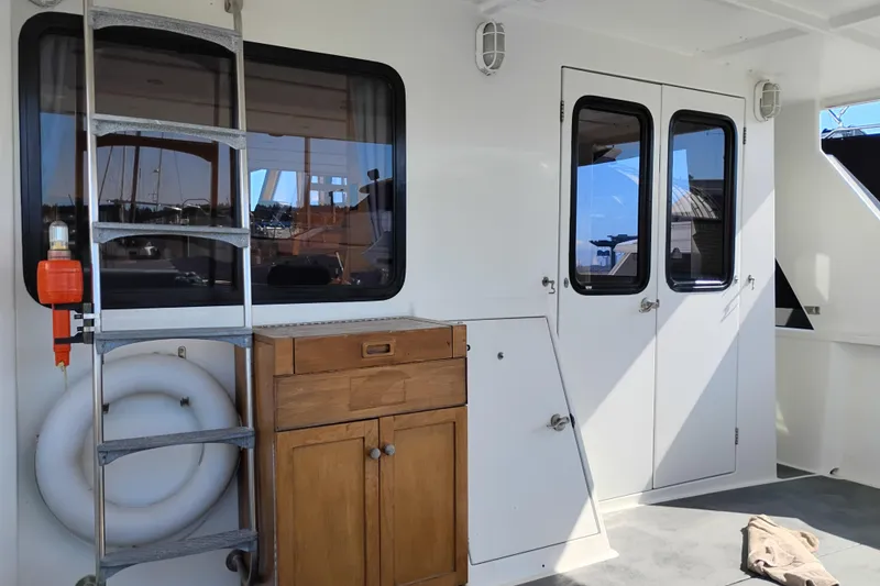 Slide: The Image of 1989 Custom Aluminum Pilothouse J Simpson interior with ladder, wooden cabinet, and life preserver. - 12