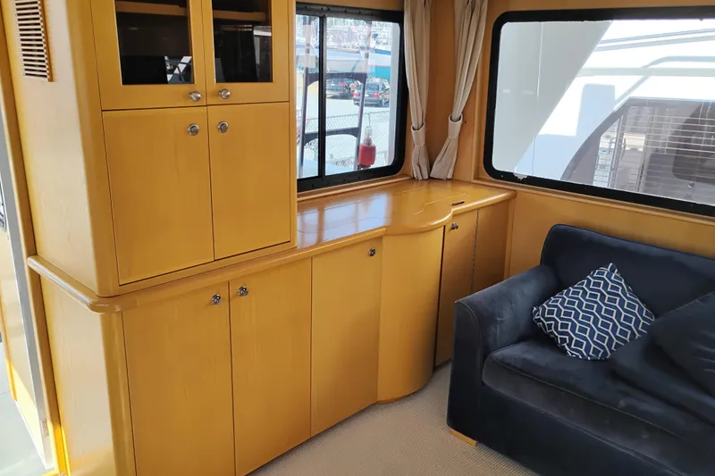 Slide: The Image of Interior of 1989 Custom Aluminum Pilothouse J Simpson with wooden cabinets and a navy sofa. - 15