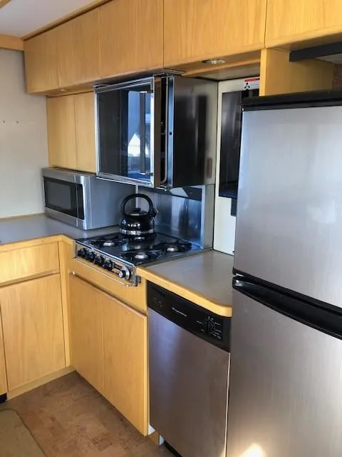 Slide: The Image of Compact kitchen in 1989 Custom Aluminum Pilothouse J Simpson with modern appliances and wooden cabinetry. - 21