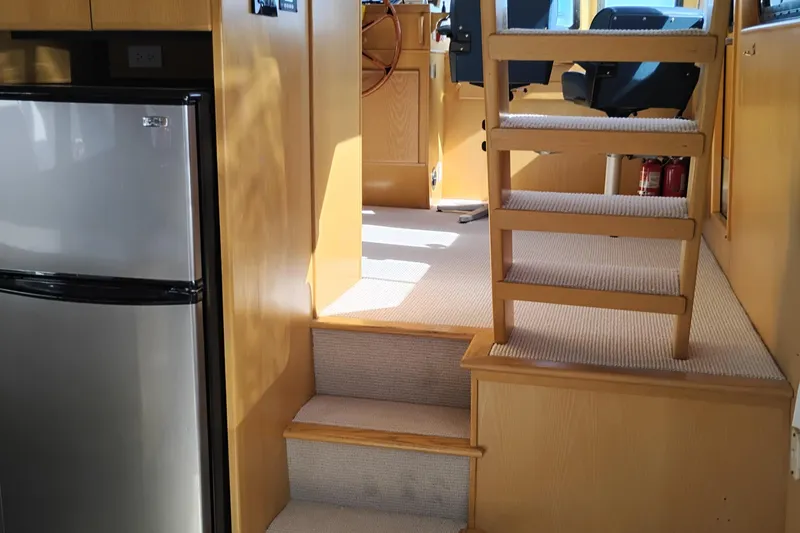Slide: The Image of Interior of 1989 Custom Aluminum Pilothouse J Simpson with stairs and compact fridge. - 25
