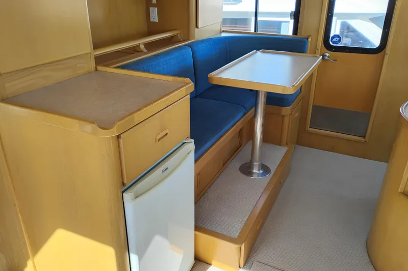 Slide: The Image of Interior of 1989 Custom Aluminum Pilothouse J Simpson with blue seating and compact kitchenette. - 26