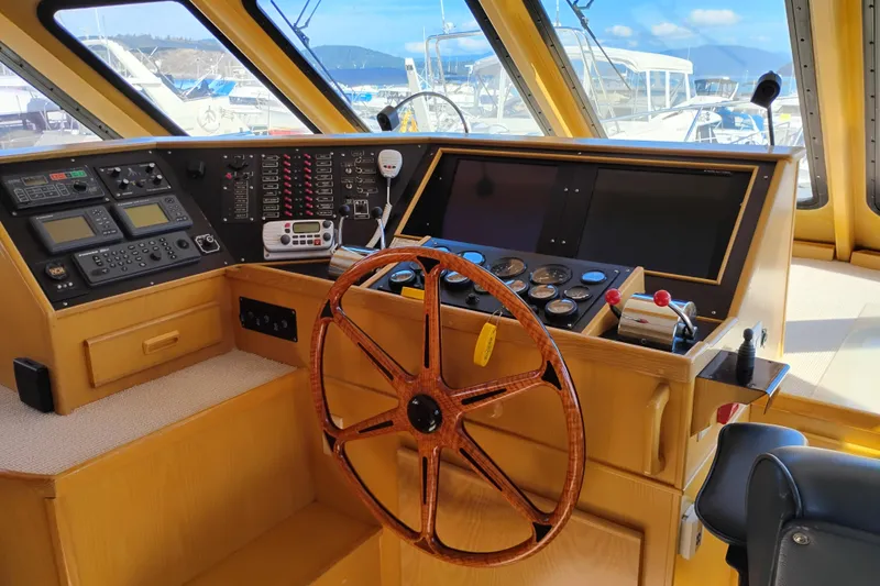 Slide: The Image of 1989 Custom Aluminum Pilothouse J Simpson interior with wooden steering wheel and control panels. - 29