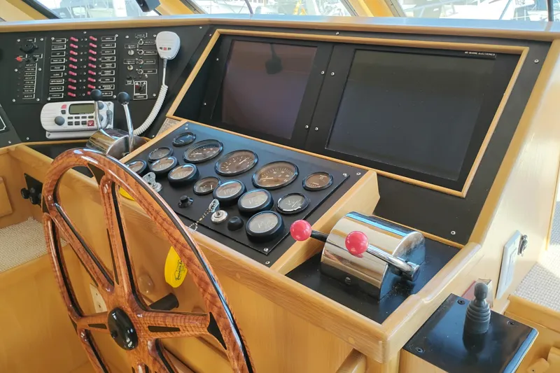 Slide: The Image of 1989 Custom Aluminum Pilothouse J Simpson helm with gauges, controls, and wooden steering wheel. - 30