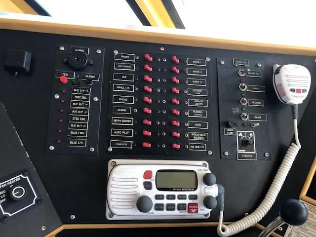 Slide: The Image of Control panel of 1989 Custom Aluminum Pilothouse J Simpson with switches and radio equipment. - 32