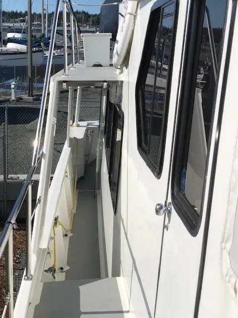 Slide: The Image of 1989 Custom Aluminum Pilothouse J Simpson boat docked, side view of walkway and windows. - 5