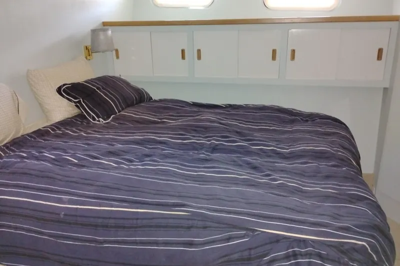 Slide: The Image of Cozy bedroom in 1989 Custom Aluminum Pilothouse J Simpson boat with striped bedding. - 50