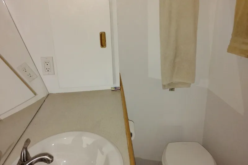 Slide: The Image of Small bathroom in 1989 Custom Aluminum Pilothouse J Simpson boat, featuring sink and toilet. - 53