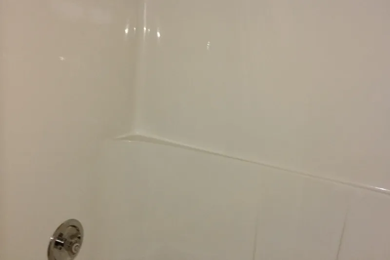 Slide: The Image of White bathroom wall with chrome shower fixture, smooth surface, minimalistic design. - 55