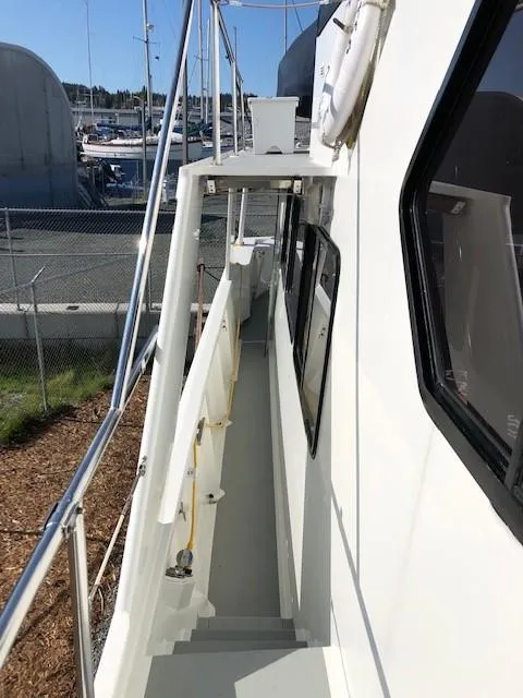 Slide: The Image of 1989 Custom Aluminum Pilothouse J Simpson boat deck with marina background. - 6