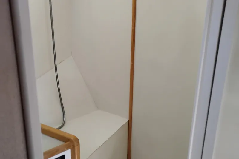 Slide: The Image of Interior of 1989 Custom Aluminum Pilothouse J Simpson, featuring minimalist white walls and wooden accents. - 62