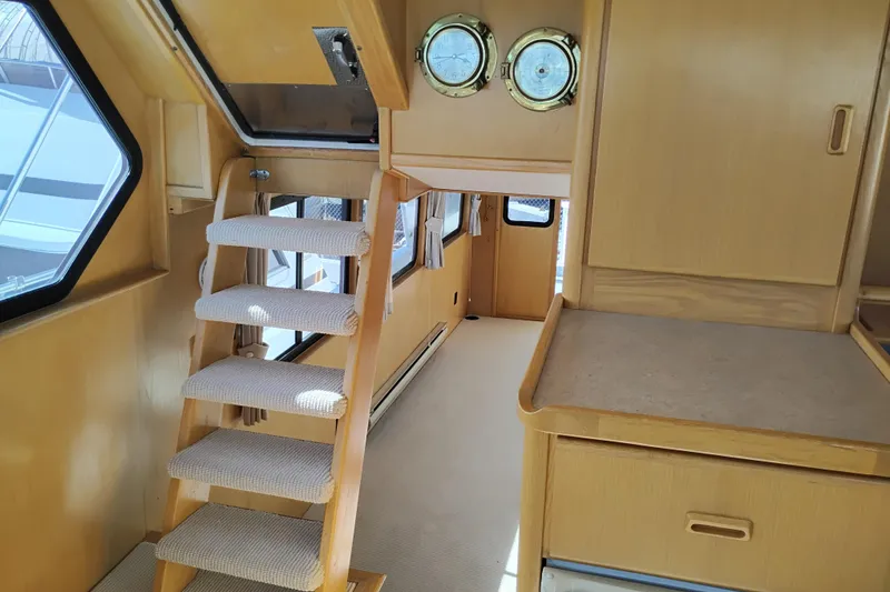 Slide: The Image of Interior of 1989 Custom Aluminum Pilothouse J Simpson with wooden stairs and nautical decor. - 68