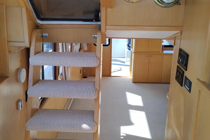 Slide: The Image of Interior of 1989 Custom Aluminum Pilothouse J Simpson with carpeted stairs and wooden cabinetry. - 69