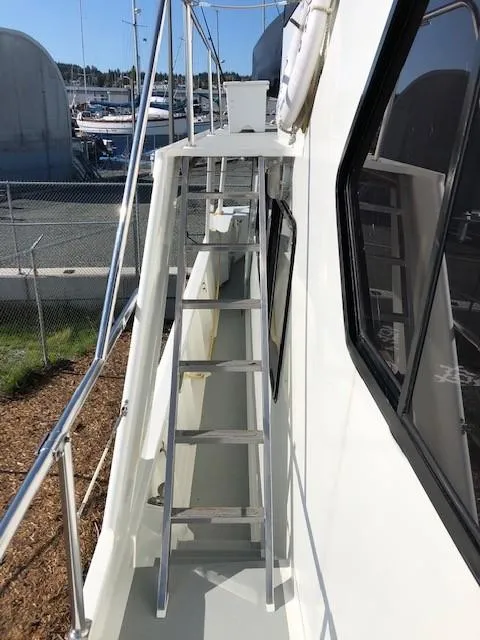 Slide: The Image of 1989 Custom Aluminum Pilothouse J Simpson boat with exterior ladder and railing, docked at marina. - 8