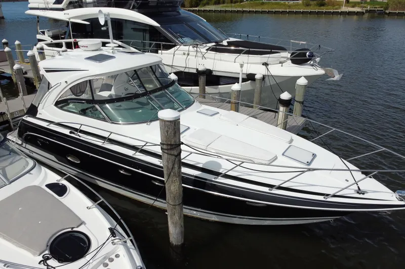 Slide: The Image of 2015 Formula 37 Performance Cruiser docked at marina, sleek design, white and black exterior. - 1