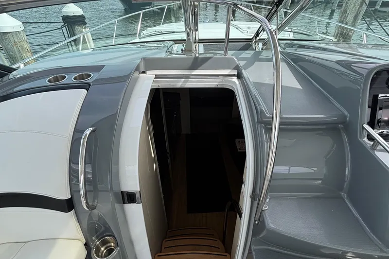 Slide: The Image of 2015 Formula 37 Performance Cruiser cockpit with open cabin door, sleek design, and waterfront view. - 27