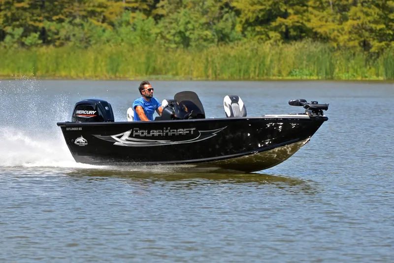 The Image of 2024 Polar Kraft 165 boat cruising on a lake with lush greenery in the background. - 1