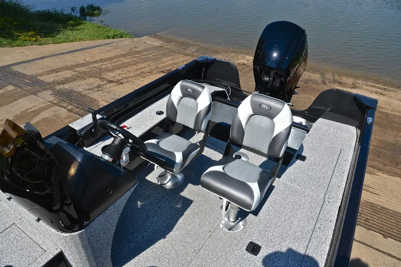 Slide: The Image of 2024 Polar Kraft 165 boat interior with dual seats and steering, near water. - 21