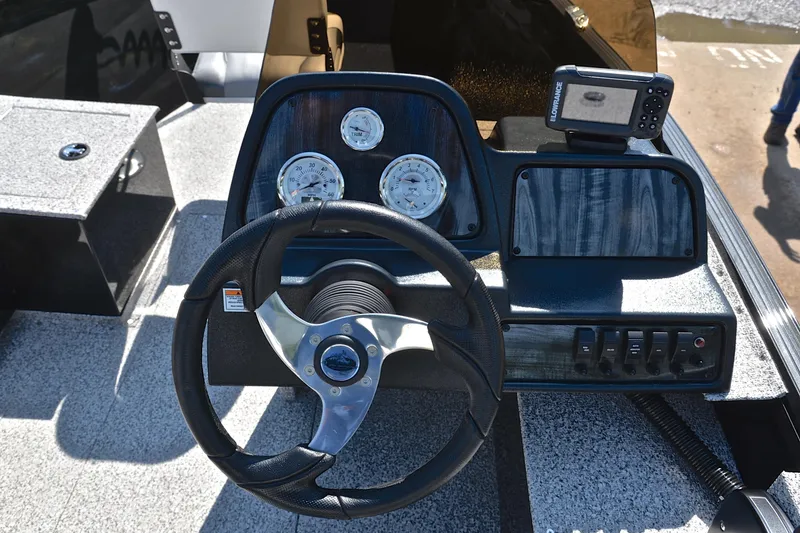 Slide: The Image of 2024 Polar Kraft 165 boat dashboard with steering wheel, gauges, and navigation system. - 23
