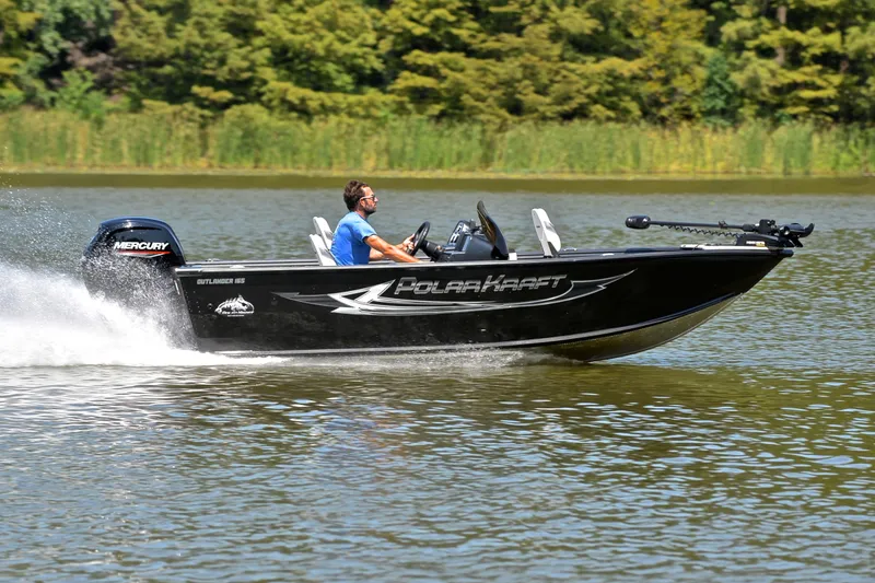 Slide: The Image of 2024 Polar Kraft 165 boat speeding on a lake with lush green background. - 3