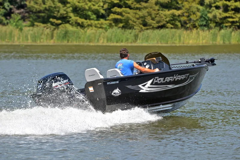 Slide: The Image of 2024 Polar Kraft 165 boat cruising on a lake with lush greenery in the background. - 5