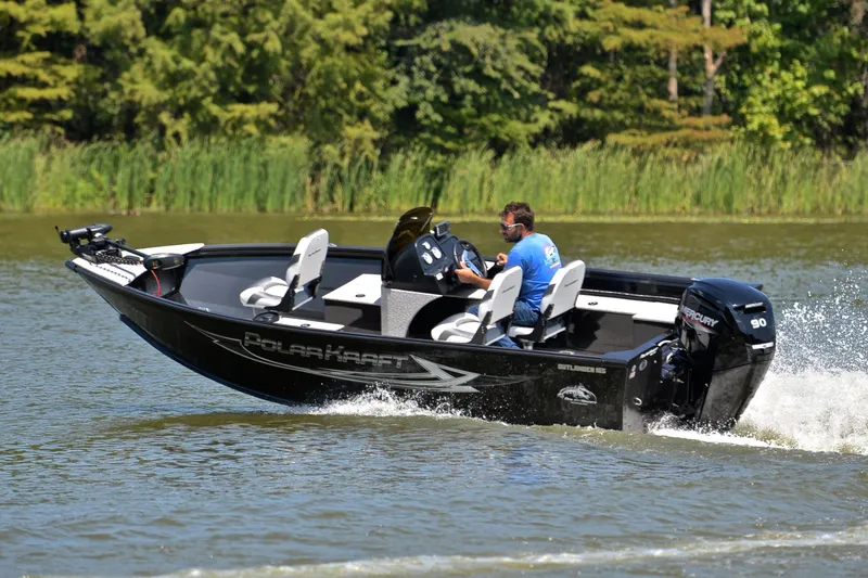 Slide: The Image of 2024 Polar Kraft 165 boat cruising on a lake with lush greenery in the background. - 6