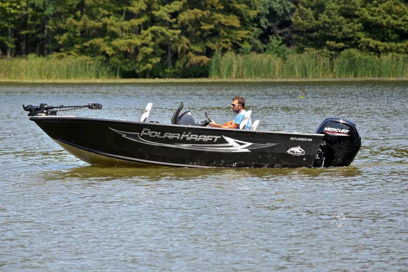 Slide: The Image of 2024 Polar Kraft 165 boat cruising on a lake with lush greenery in the background. - 9