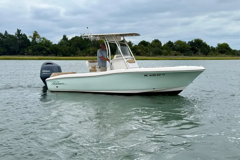 Slide: The Image of 2016 Pioneer 197 Islander boat on water with Yamaha engine, surrounded by trees. - 2