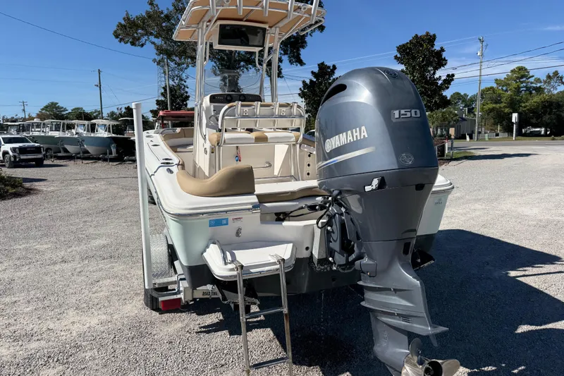 Slide: The Image of 2016 Pioneer 197 Islander boat with Yamaha 150 outboard motor, parked on gravel. - 23