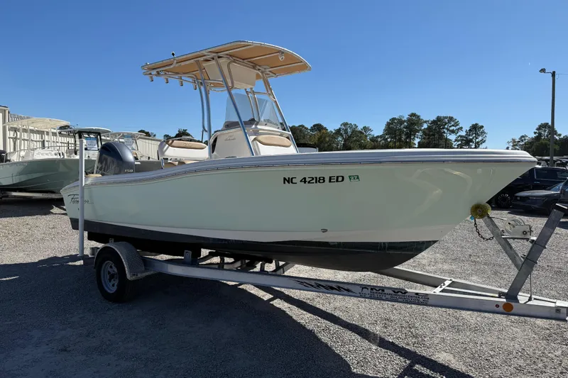 Slide: The Image of 2016 Pioneer 197 Islander boat on trailer, parked outdoors under clear blue sky. - 28