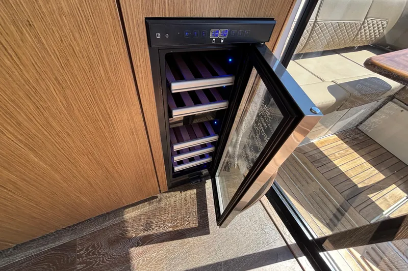 Slide: The Image of Open wine cooler on 2018 Sea Ray Sundancer 460 yacht, showcasing wooden interior and glass door. - 11