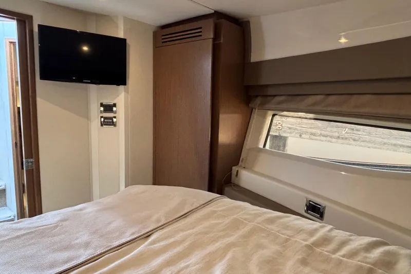 Slide: The Image of 2018 Sea Ray Sundancer 460 cabin interior with bed, TV, and window view. - 31