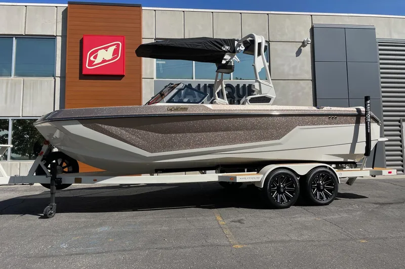 The Image of 2026 Nautique Super Air Nautique GS22 boat on trailer outside dealership. - 1