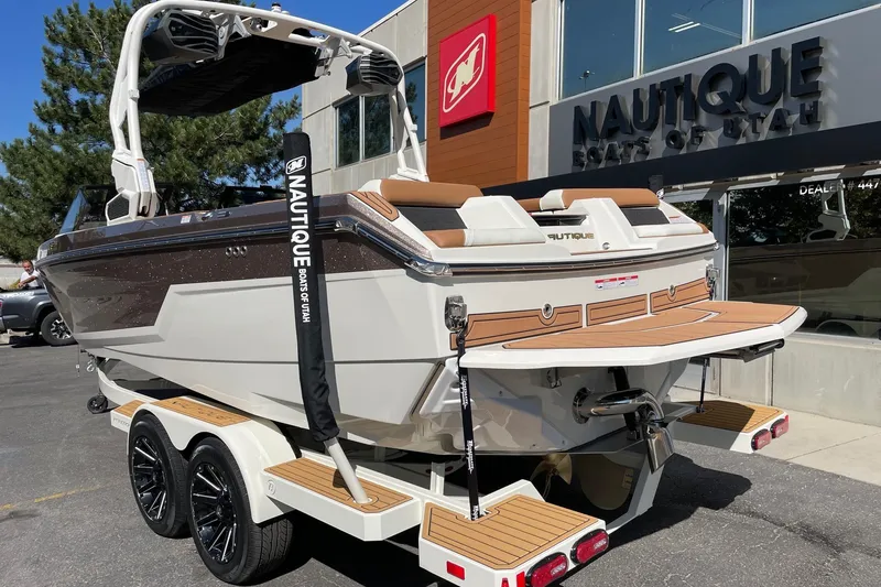 Slide: The Image of 2026 Nautique Super Air Nautique GS22 boat displayed at dealership, rear view. - 3