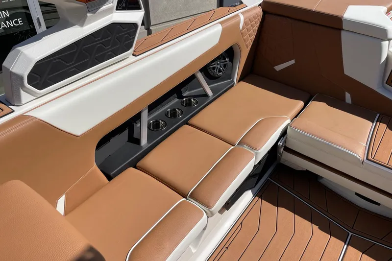 Slide: The Image of 2026 Nautique Super Air Nautique GS22 interior with tan leather seating and cup holders. - 7