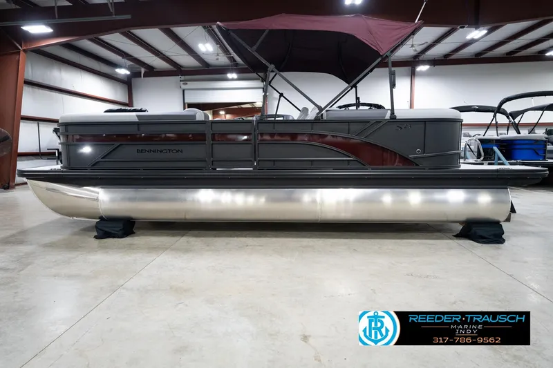 Slide: The Image of 2026 Bennington 23 SSR pontoon boat in showroom with maroon canopy. - 10