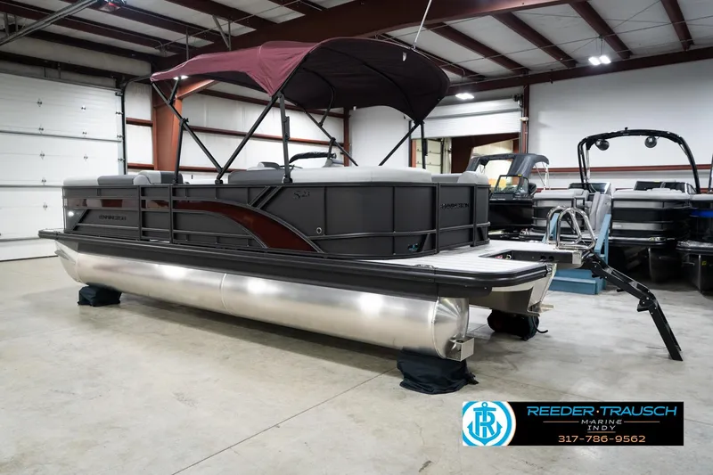 Slide: The Image of 2026 Bennington 23 SSR pontoon boat in showroom with maroon canopy. - 9
