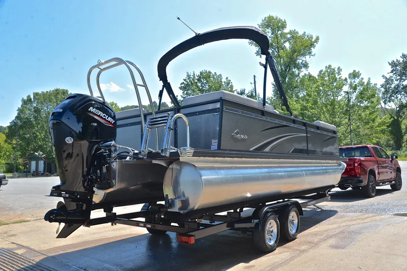 Slide: The Image of 2023 Qwest LT 822 pontoon boat on trailer, attached to red truck, outdoors. - 14