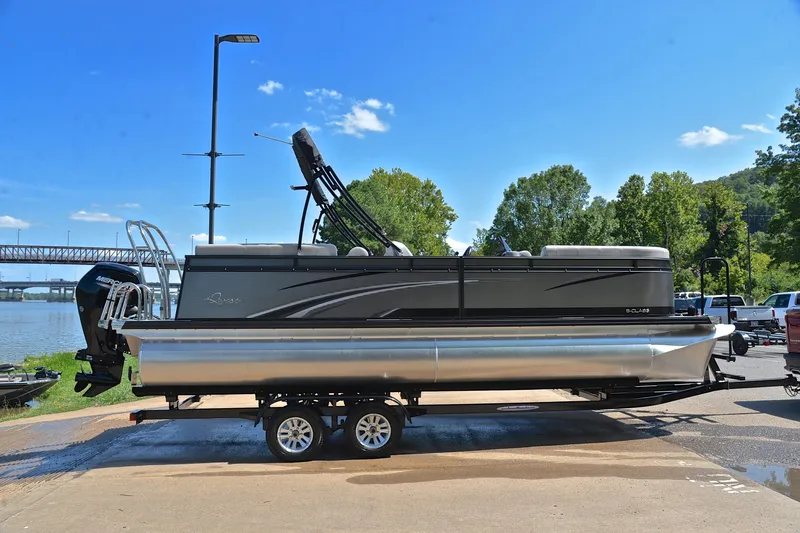 Slide: The Image of 2023 Qwest LT 822 pontoon boat on trailer by riverside, clear sky background. - 15