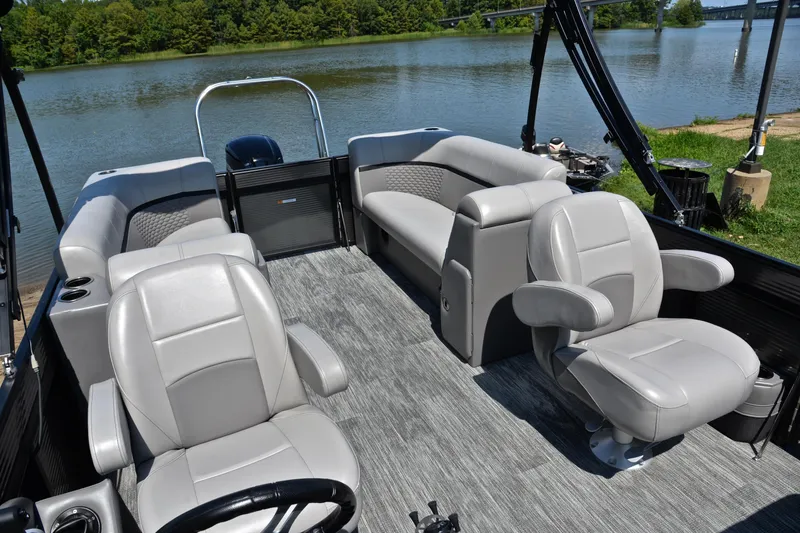 Slide: The Image of 2023 Qwest LT 822 pontoon boat interior with gray seating, on a scenic lake. - 22