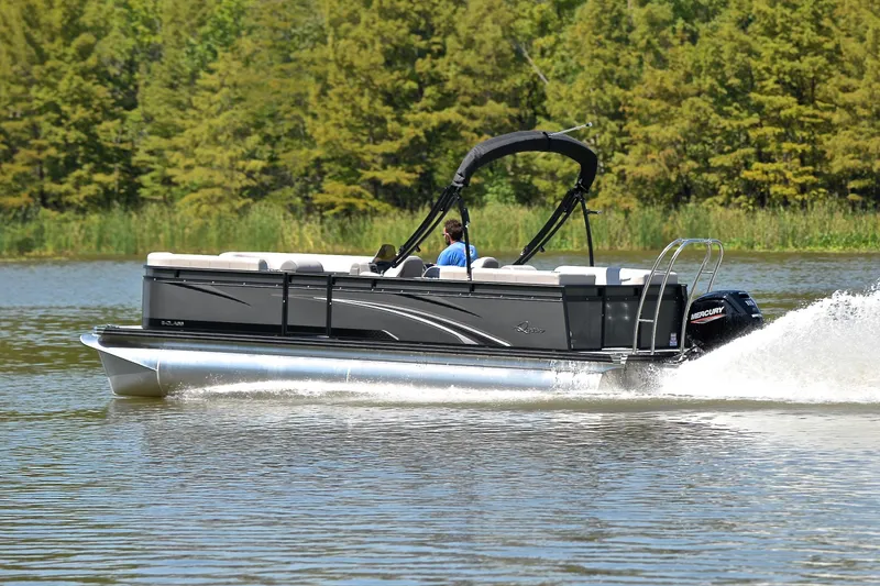 Slide: The Image of 2023 Qwest LT 822 pontoon boat cruising on a lake with lush green trees. - 4