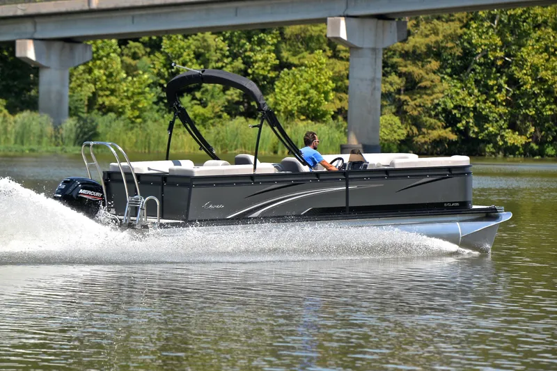 Slide: The Image of 2023 Qwest LT 822 pontoon boat cruising on a scenic river under a bridge. - 5