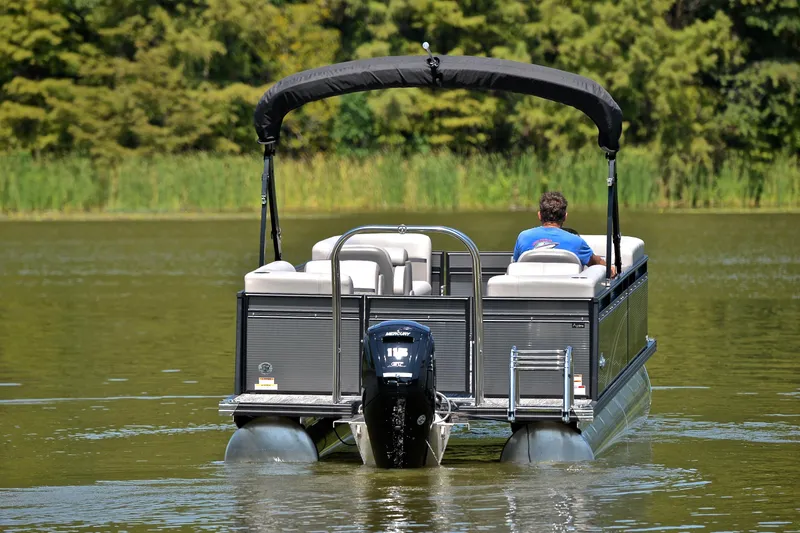 Slide: The Image of 2023 Qwest LT 822 pontoon boat cruising on a serene lake. - 7