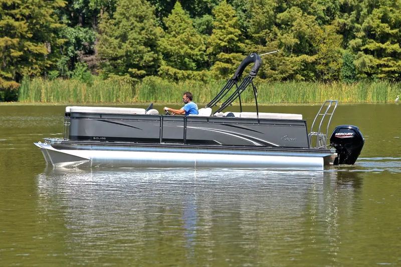 Slide: The Image of 2023 Qwest LT 822 pontoon boat cruising on a serene lake with lush greenery. - 8
