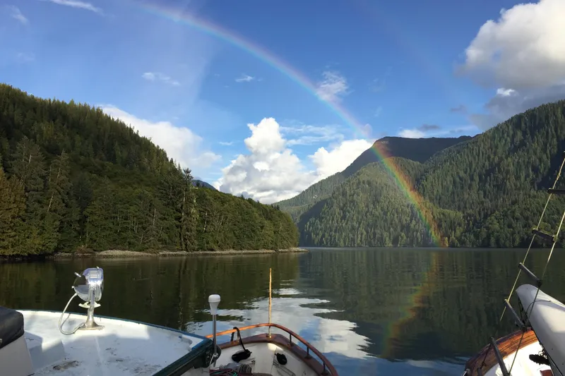 Slide: The Image of Southern Marine MALAHIDE Pilothouse LRC (1971) cruising under a vibrant rainbow in a serene lake. - 33